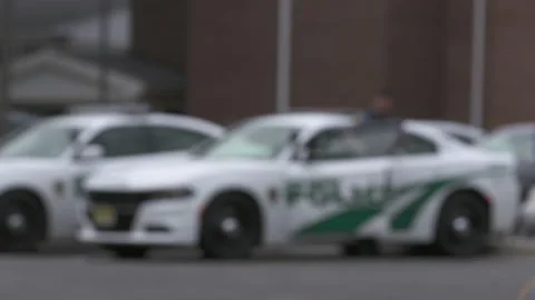 Police Walking through Precinct Parking Lot Blurry 4K Stock Footage 145998248