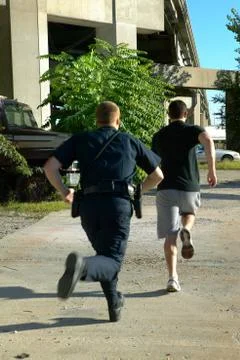 Policeman chasing after suspect man Foto stock