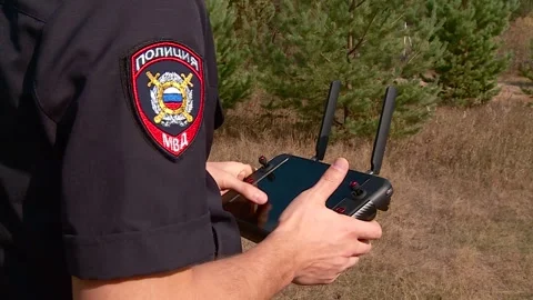 The policeman controls the remote control from the drone Stock Footage 336845990