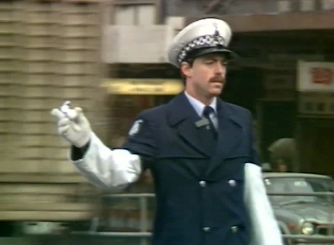 POLICEMAN DIRECTING TRAFFIC, FLINDERS ST, MELBOURNE, AUSTRALIA (1984) Video stock 251943172