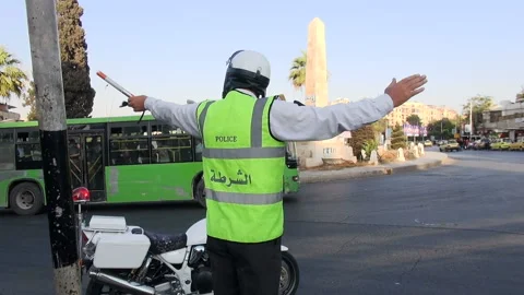 Policeman directing traffic at an intersection in Aleppo, Syria Video stock 155313833