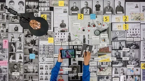 Policeman flips through the photo on the tablet Top view of the detective's desk Stock Footage 80933869