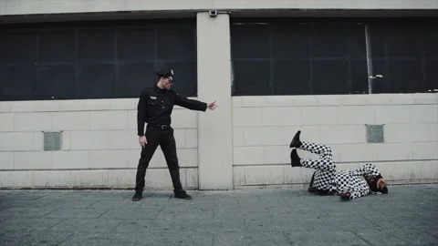 Policeman pointing at a falling jester on the street Stock Footage 331599882