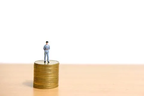 Policeman standing above coin stack to protect money. Stock Photos