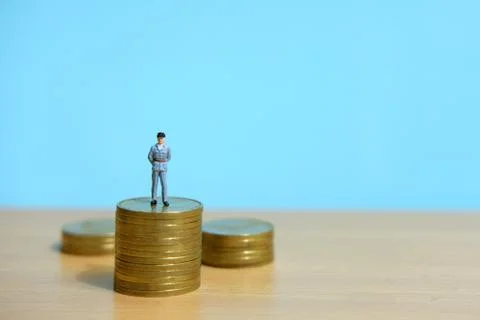 Policeman standing above coin stack to protect money. Foto stock