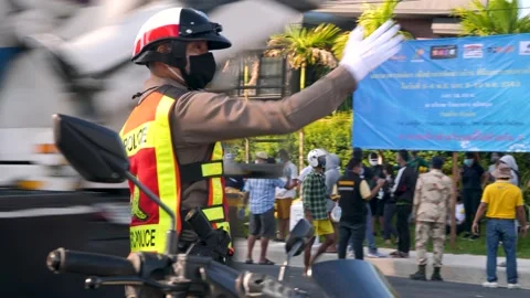 Policeman in uniform and in protective face mask regulates traffic Stock Footage 139586141