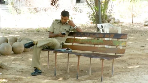 Policemen Sitting On The Bench And Using Mobile phone Stock Footage 76110356