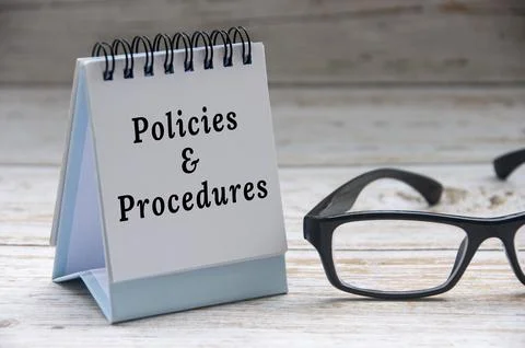 Policies and procedures text on notepad with glasses on white wooden cover .. Stock Photos