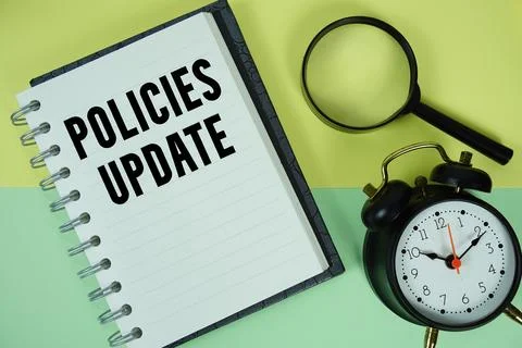 Policies Update text written on notebook paper with magnifying glass and al.. 스톡 사진