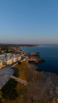 Polignano a mare townscape featuring white buildings perched on rocky cliffs, ov Stock Photos
