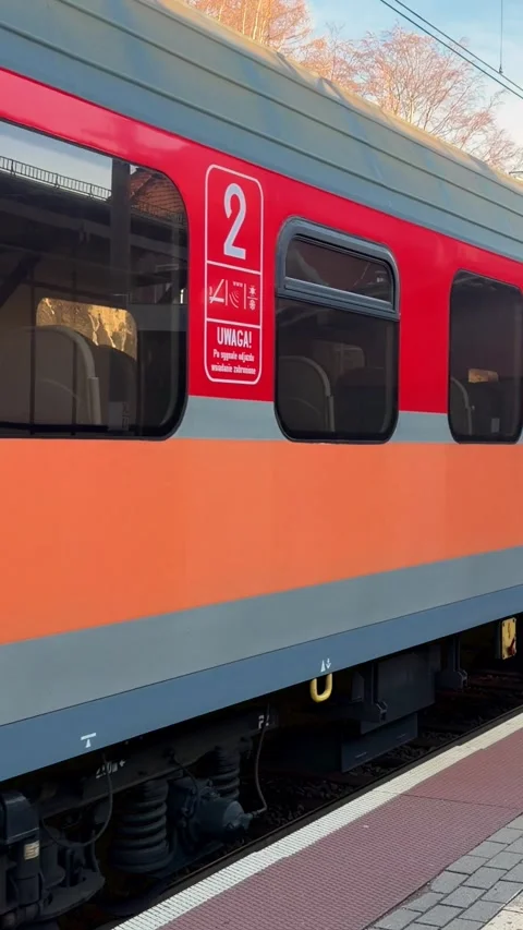 A Polish passenger train arriving at a station platform, showcasing modern rail Stock Footage 345743025