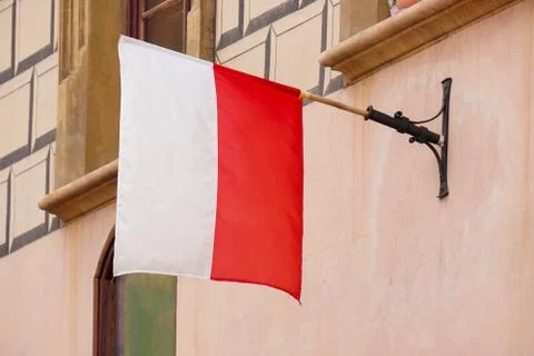 Polish white-red flag in wind on wall of the block or house. Natural Light Se Stock Photos