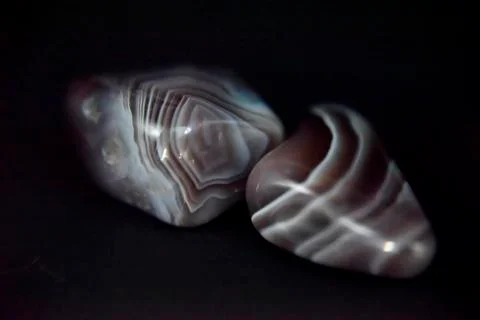 Polished agate on the dark background with the side light. Stock Photos