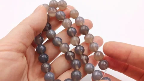 Polished gray agate gemstone beads presented on strands for jewelry crafting Stock Footage 345139633
