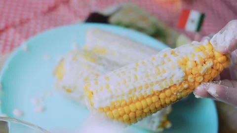 Polished kitchen study: turning coated corn for even coverage Stock Footage 342171864