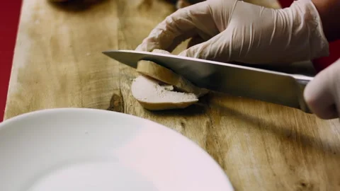 Polished knife working through tender poultry on a wooden board in macro, 4K Vidéo 341109329