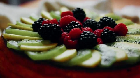 Polished low angle across berries and green kiwi slices in warm light, 4K Stock Footage 341116206