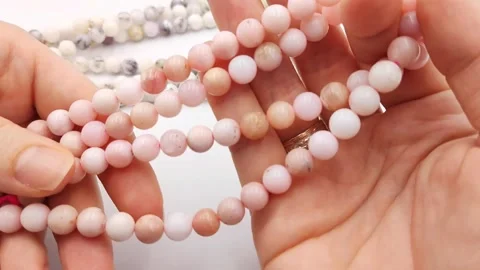 Polished pink opal gemstone beads arranged for jewelry design supplies Stock Footage 345139707