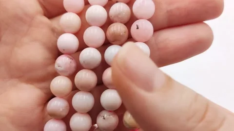 Polished pink opal gemstone beads arranged for jewelry design supplies Stock Footage 345139708