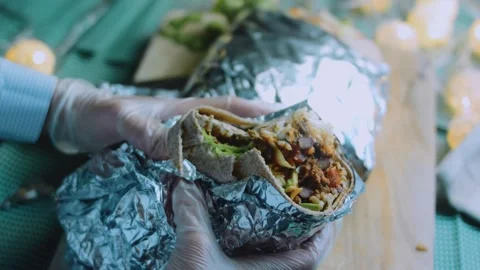Polished tabletop view: halved burrito revealing beef and vegetables Stock Footage 342168487