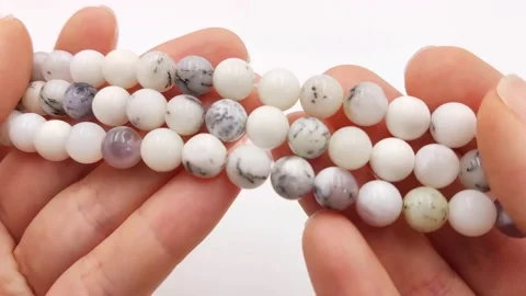 Polished white round gemstone bead strands featuring natural dendrites Stock Footage 345139691