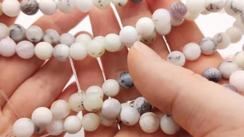 Polished white round gemstone bead strands featuring natural dendrites Stock Footage 345139706