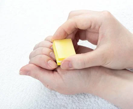 Polishing nails with a mini-buff over a light towel. Stock Photos