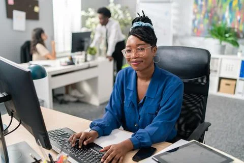 Polite, elegant customer service representative in large corporation sits at Stockfoto's