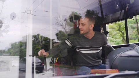 Polite professional transport operator sits on driver's seat, takes fare and Stock Footage 258799272
