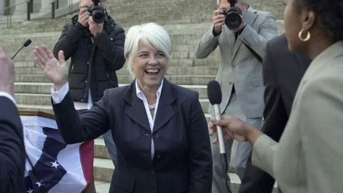 A politician giving interviews while walking among her supporters 스톡 동영상 76235787