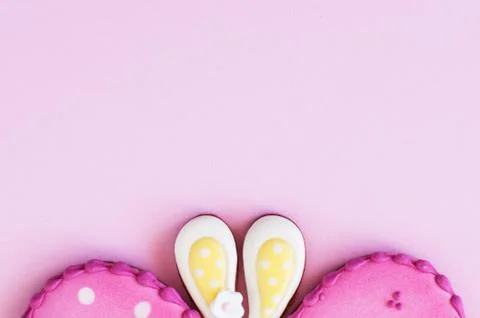 Polka dot easter egg and bunny ear cookies on a pink background. Stock Photos