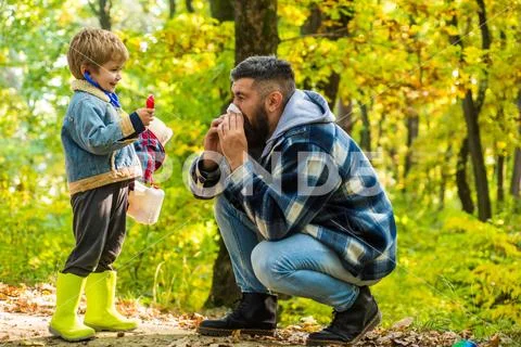 Pollen allergy concept. Father sneezing allergic reaction. Seasonal allergy. Kid Stock Photos