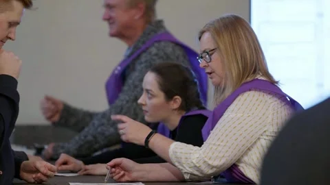 Polling staff issue ballot papers to voters at Australia House Stock Footage 345298972