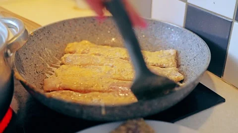 Pollock Fillet Frying in Egg Batter on Pan in Home Kitchen Warm Light Stock Footage 324939857