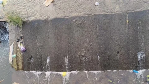 Polluted Drain Water Flowing Over Concrete Barrier Видео 330325580