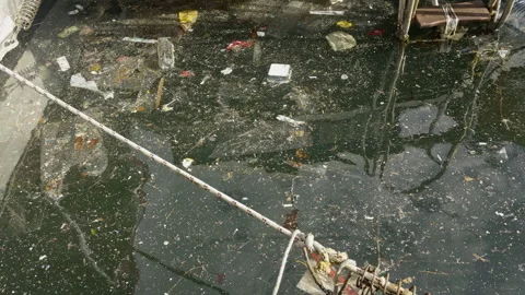 Polluted Harbor Water Filled with Floating Plastic Waste Stock Footage 327946574
