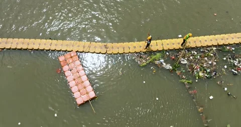 Polluted river with a barrier to trap debris. Indonesia, Jakarta. Stock Footage 346600647