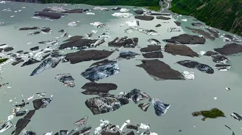 Polluted river with floating trash and rocks in nature Stock-Fotos