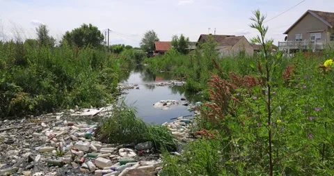 Polluted river with plastic bottles and garbage, environmental contamination Stock Footage 274664052