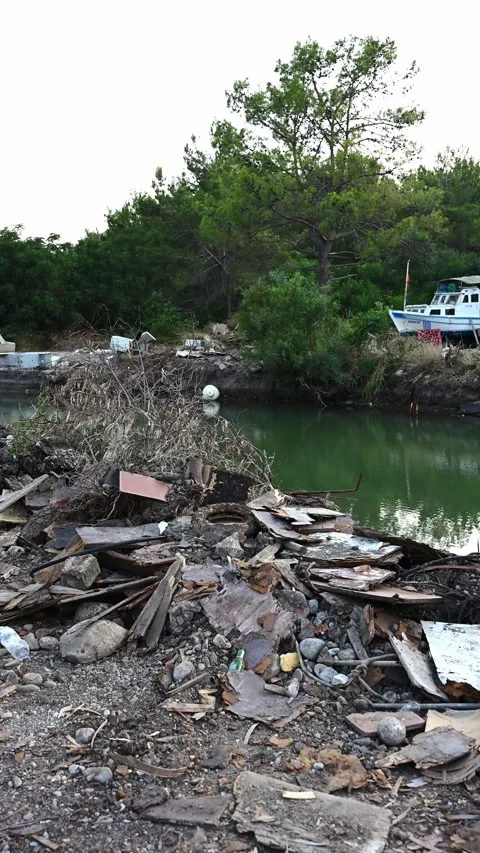Polluted shoreline. Littered shoreline with floating debris, abandoned illegal Stock Footage 330951473