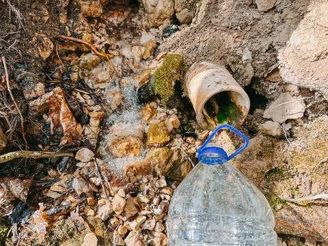 Polluted Stream Flowing from Drain Pipe with Plastic Bottle Stock Photos