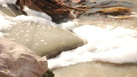Polluted water flowing into river, Dirty water containing chemicals foam Stock Footage 148197859