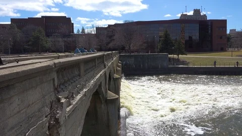 Polluted water flows from the Flint River through Flint, Michigan during their Stock Footage 79392289