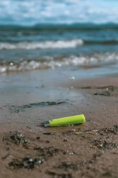 Pollution on the beach, discarded lighter. Stock-Fotos