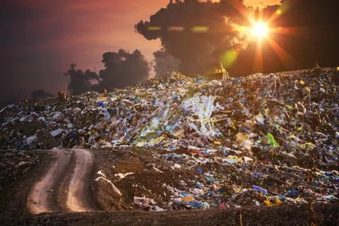 Pollution concept. Garbage pile in trash dump or landfill at twilight. Stock Photos