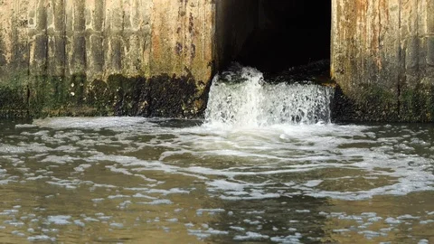 Pollution drain flowing stream to a river Stock Footage 87026767