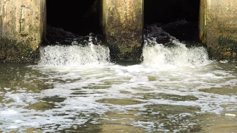 Pollution drain flowing stream to a river Stock Footage 87026771