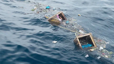 Pollution floats on dark blue ocean water surface in natural environment. Video stock 328030433