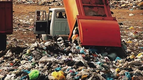 Pollution pattern. Red trash truck spills garbage in a landfill. Stock Footage 143846746