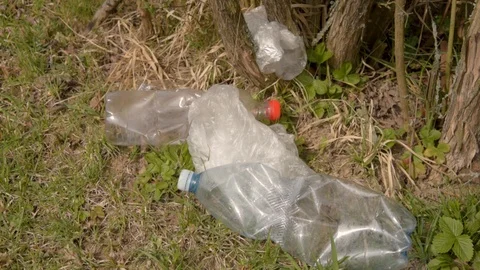 Pollution of plastics on the ground. Garbage collection. Hand cleans plastic Stock Footage 106448868